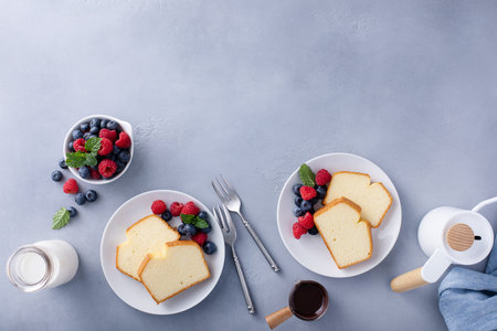 Classic pound cake sliced served with fresh raspberries and blueberries