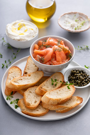 Making salmon and cream cheese bruschetta with fresh dill and capersの写真素材