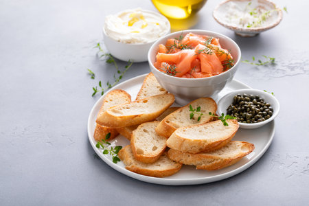 Making salmon and cream cheese bruschetta with fresh dill and capersの写真素材