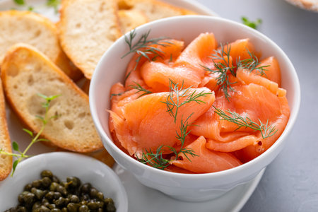 Making salmon and cream cheese bruschetta with fresh dill and capersの写真素材