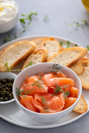 Making salmon and cream cheese bruschetta with fresh dill and capersの写真素材