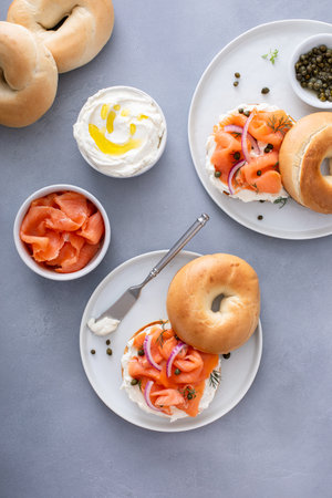 Plain bagel with salmon and cream cheese with fresh dill and capers for breakfastの写真素材