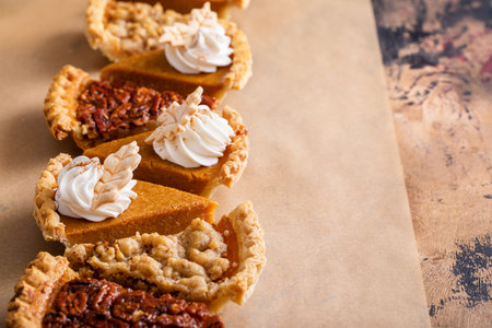 Thanksgiving pies slices on parchment paper, pumpkin and pecan pieの写真素材