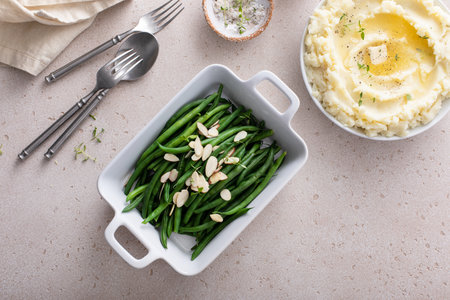 Green beans topped with almonds in a baking dish, traditional side dish for every day dinner or celebrationの写真素材
