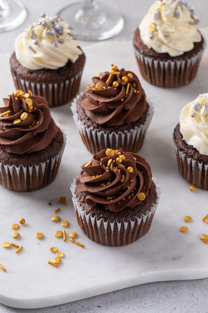 Festive cupcakes for a New Years Eve party, chocolate and vanilla frosting with sparkling sprinklesの写真素材