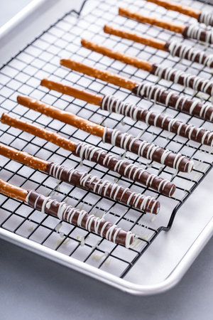 Chocolate dipped pretzel rods with dark and white chocolate on a cooling rackの写真素材