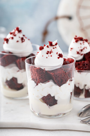 Red velvet cake in a cup, trifle or individual dessert idea with cream cheese frosting and whipped creamの写真素材