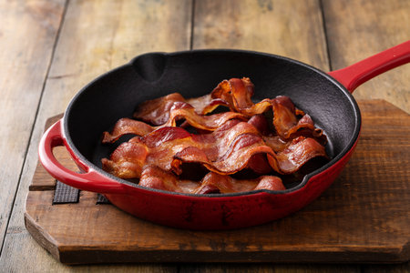 Crispy bacon in a cast iron skillet cooked and ready to eatの写真素材