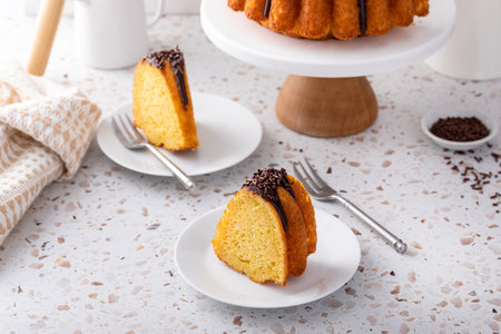 Orange bundt cake topped with chocolate ganache and chocolate sprinkles cut into slicesの写真素材