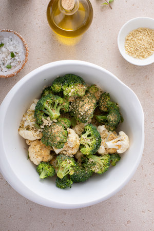 Cooking with broccoli and cauliflower, getting ready to roast vegetables with spices, bread crumbs and olive oilの写真素材