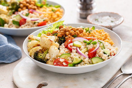 Vegan lunch bowl with roasted vegetables, fresh lettuce, cooked lentils, couscous salad and crunchy roasted chickpeasの写真素材