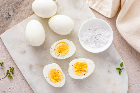 Hard boiled eggs peeled and cut in half with salt and pepper