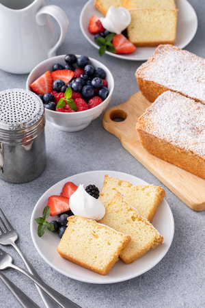 Traditional vanilla pound cake sliced and served with whipped cream and fresh berriesの写真素材