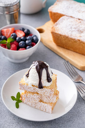Traditional vanilla pound cake sliced and served with ice cream and fresh berriesの写真素材