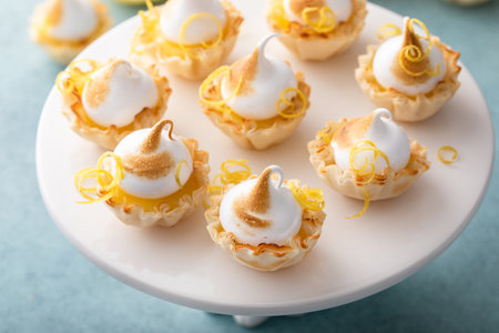 Lemon meringue tartlets with lemon curd in filo pastry shellsの写真素材