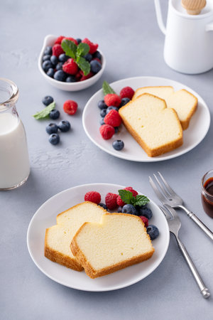 Pound cake slices served with fresh berries, chocolate syrup and coffeeの写真素材
