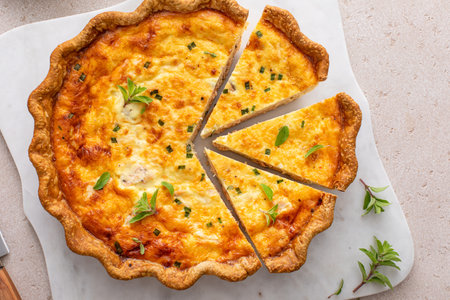 Salmon and cheese quiche with herbs freshly baked for breakfast, sliced on a cutting boardの写真素材