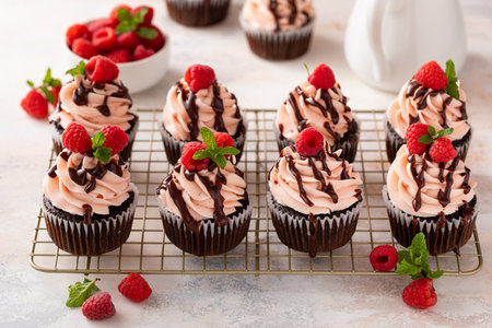 Raspberry chocolate cupcakes with raspberry buttercream frosting a drizzle of chocolate glazeの写真素材