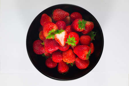 Fresh strawberry In a black cup and white background.の写真素材