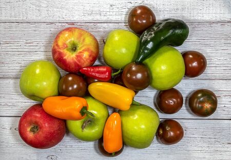 Group of  fresh apples, tomatoes, and pepper flat lay on a wooden backgroundの写真素材
