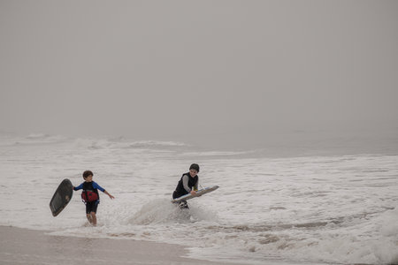 Half Moon Bay, California - September 13, 2020: Kids playing in the water on a smoky day at Poplar Beach near Half Moon Bay, Californiaのeditorial素材
