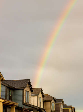 Rainbow over the row of new houses after a thunderstorm in Denver, Coloradoの写真素材