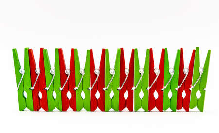 red and green colorful wooden clothespins on a white backgroundの写真素材