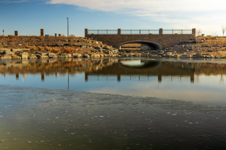 Beautiful early spring landscape with a pond and reflections in the small neighborhood park in Aurora, Coloradoの写真素材
