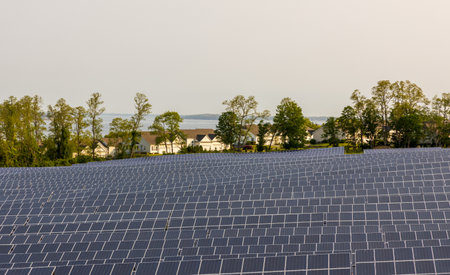 Newport, Rhode Island. Solar panels mounted on the ground in the suburban coastal area. Ocean view...