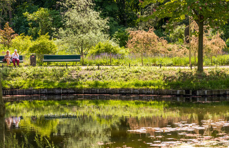 Berlin, Germany - May 31, 2023: The Tiergarten, beautiful park in central Berlin, people sitting on the benchのeditorial素材