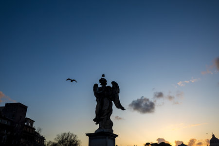 Angel statue on St. Angelo Bridge in Rome, Italy, at nightの写真素材