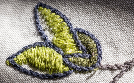 Closeup of embroidered green leaf on a white clothの写真素材