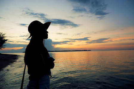 Girl silhouette during the sunset by the beach on Gili Air island, Lombok, Indonesiaの写真素材