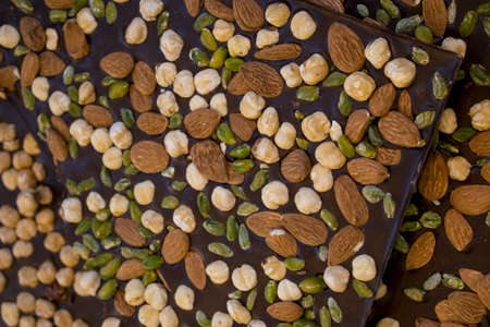 Some pieces of brown chocolate with almons, nuts and pistachioの写真素材