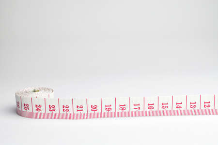 An image of a rolled tape measure on a white backgroundの写真素材