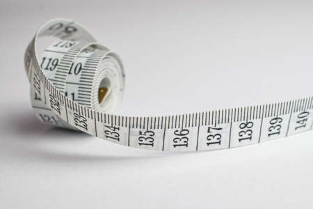 An image of a rolled tape measure on a white backgroundの写真素材