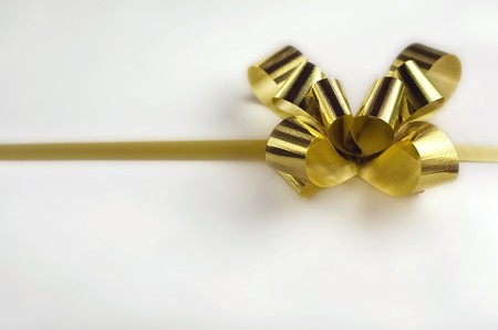 Gift golden ribbon and bow isolated on whiteの写真素材
