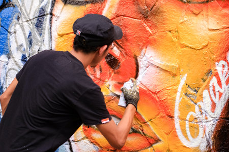 Young man is drawing graffiti art on the wallの写真素材