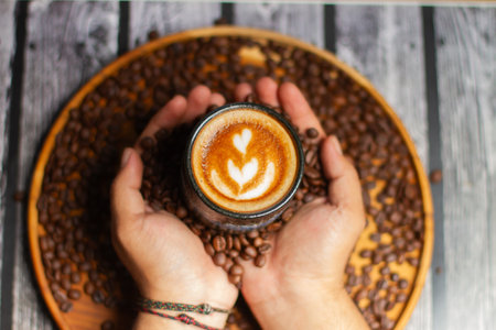 A cup of coffee with latte art on a wooden background.の写真素材