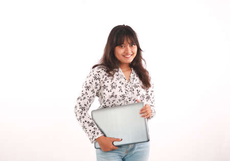 Portrait of an excited young beautiful girl holding laptop computer and celebrating success isolated...