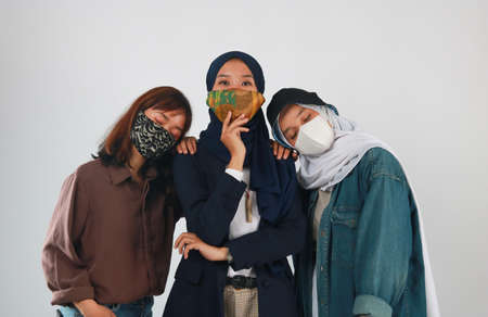 Three Woman wearing face mask during coronavirus outbreak isolated on pink background.の写真素材