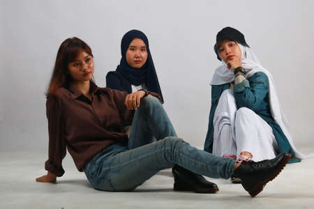 Fashion portrait of three best friends posing in studioの写真素材