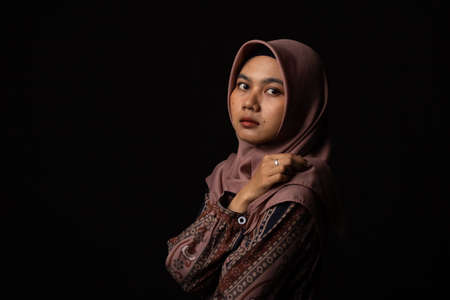 Fashion portrait of young beautiful asian muslim woman with wearing hijab isolated on black...