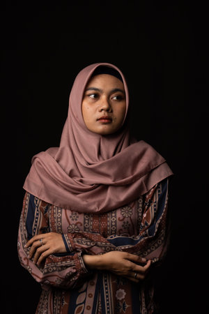 Fashion portrait of young beautiful asian muslim woman with wearing hijab isolated on black backgroundの写真素材