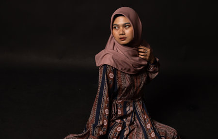 Fashion portrait of young beautiful asian muslim woman with wearing hijab isolated on black backgroundの写真素材