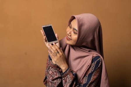 portrait of Asian Woman using smartphone on gold background.の写真素材