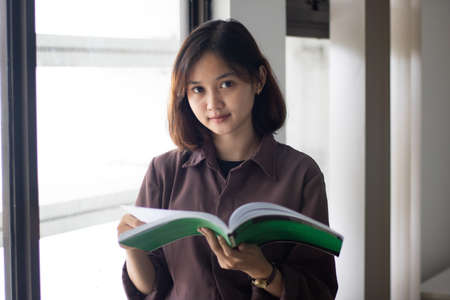 Attractive african american girl enjoying reading a book.の写真素材