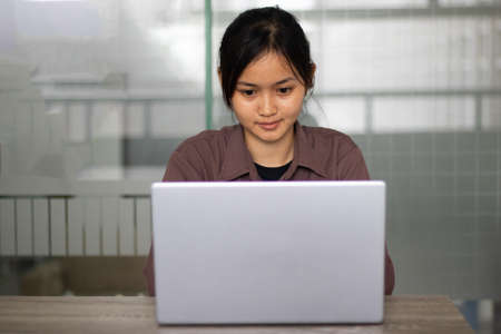 Asian student woman working on a laptop during the dayの写真素材
