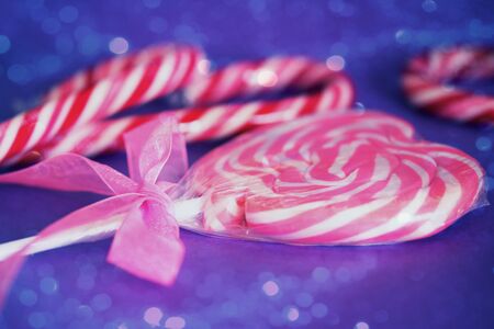 a pink heart lollipop with cute ribbon with bokeh overlayの写真素材