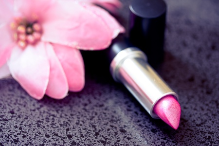 cosmetics: lipstick shot next to a pink flowerの写真素材